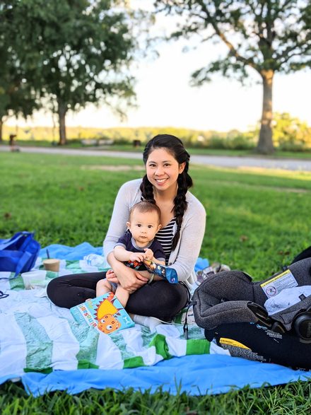 A family sitting together on a picnic blanket in a park