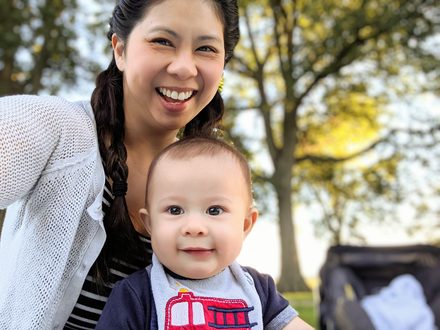 A parent and a smiling baby under golden evening light